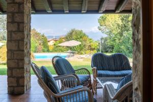 - un ensemble de chaises assises sur une terrasse avec piscine dans l'établissement Villa Punta Sasso, à Manerba del Garda