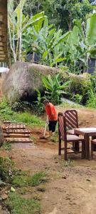 un uomo è in piedi accanto a una grande roccia di Camping Cítara a Parati Altre 8 foto