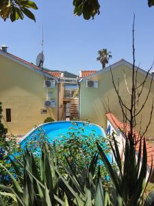 a blue car parked in a yard with plants at Luxury 3BR Duplex with Pool 2 Mins from Beach in Kumbor in Herceg-Novi