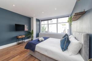 Un dormitorio con una cama grande y una ventana grande. en JoysPick Seafront Studio BN144CLA02, en Brighton & Hove