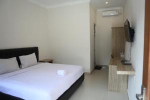Postel nebo postele na pokoji v ubytování Rahayu Hotel Cirebon