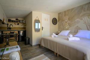 a bedroom with two beds and a kitchen with a table at Ca'Bercé Studio équipé in Château-du-Loir
