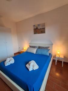 a bedroom with a blue bed with towels on it at Sospesi nel borgo in Vitorchiano