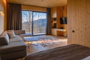 a living room with a couch and a large window at Panorama Skhidnytsya SPA Resort in Skhidnitsa