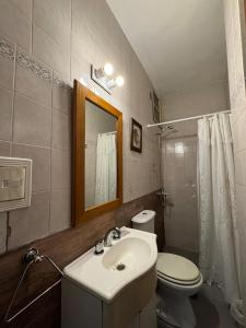 a bathroom with a sink and a toilet and a mirror at Apartamento Premium Mendoza 2 in Mendoza +24 photos