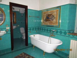 een blauwe badkamer met een bad en een toilet bij Villa Maria Bed & Breakfast, Corridonia, Marche in Corridonia