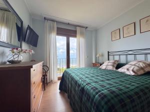 a bedroom with a bed and a television and a window at ROOMS PEREGRINOS A Casa Alicia in Rosal