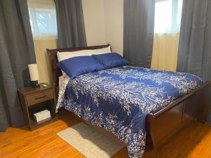 a bedroom with a bed with a blue comforter and a window at Bachome in Kettering
