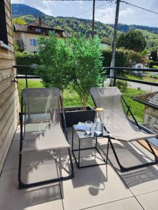 two chairs and a table on a patio at Studio lumineux avec grande terrasse et vue lac, Parking privé in Lugrin