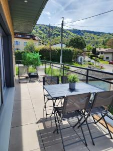 a patio with a table and chairs on a balcony at Studio lumineux avec grande terrasse et vue lac, Parking privé in Lugrin +17 photos