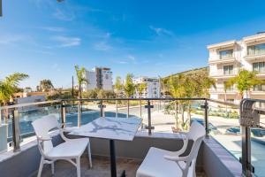 a balcony with a table and chairs and a pool at Heksamil Hotel in Ksamil