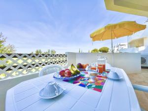 a white table with food on top of a balcony at Albufeira Balaia Golf Vilage 7 With Pool by Homing in Albufeira