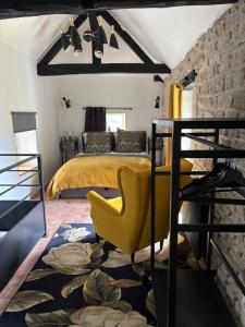 una camera da letto con un letto e una sedia gialla di La petite Chapelle a LʼIsle-sur-Serein
