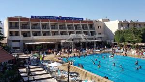a group of people in a swimming pool in front of a hotel at فندق الخيال الكبير in Zahlé