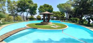 a large swimming pool with a fountain in a park at Casa Elviras in Alcossebre