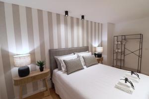 a bedroom with a bed with a striped wall at Casa "Patota" - Nazaré - Alojamento Local in Nazaré