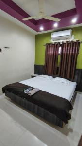 a large bed in a room with a ceiling at New Palange Bhakt Niwas in Tuljapur