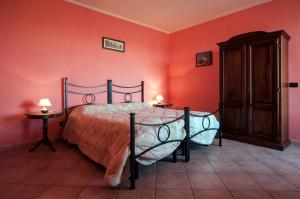 a bedroom with a bed in a red wall at Agriturismo Al Brich in Albaretto Della Torre 