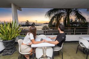 a man and a woman sitting at a table on a balcony at Park Hotel in Santa Marta