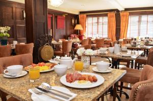 a breakfast table with eggs and bacon in a restaurant at Celtic Lodge Guesthouse - Restaurant & Bar in Dublin