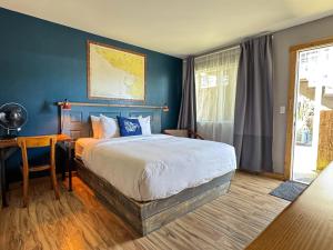 a bedroom with a large bed with a blue wall at Salt Hotel & Pub in Ilwaco +58 photos