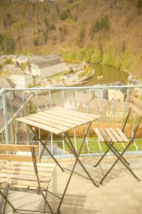 布永Le Chalet的阳台上摆放着野餐桌和两把椅子