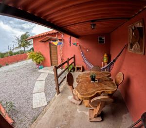 a patio with a wooden table and a house at Chalé Raiz da Serra in Gravatá