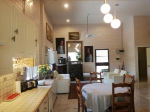 a kitchen and living room with a table and chairs at Thai River House in Ban Kat Khi Lek