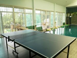 a ping pong table in a room with a swimming pool at Thai River House in Ban Kat Khi Lek