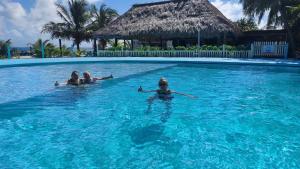 a group of people swimming in a swimming pool at Royal Caribbean Resort in San Pedro