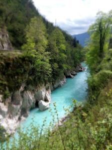 a river with blue water in the middle of a mountain at Apartma 47 in Kobarid