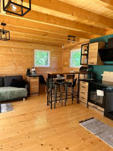 a kitchen with a table and chairs in a cabin at Domki w brzozach in Brajniki