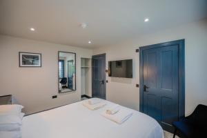 a bedroom with a white bed with a blue door at The Righ in Oban