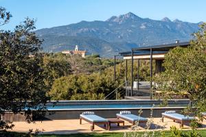 ein Haus mit Pool und Bergen im Hintergrund in der Unterkunft Casa Nera in Pianottoli-Caldarello
