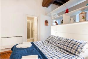 Un dormitorio con una cama azul y blanca y estanterías en Apartment Magnoli&Ponte Vecchio, en Florencia 7 fotos más