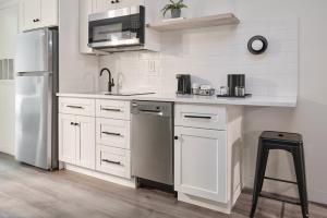 a kitchen with white cabinets and a stainless steel refrigerator at Hive House in Cary