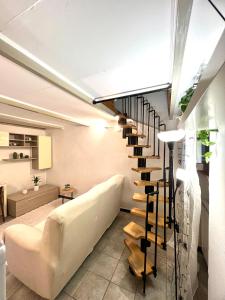 a spiral staircase in a living room with a white couch at Appartamento con soppalco e parcheggio privato Cornaredo, Fiera Milano Cortina 2026 in Cornaredo