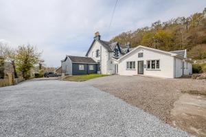 a white house with a driveway in front of it at The Righ in Oban +56 photos