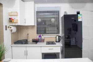 a small kitchen with a sink and a refrigerator at Optimum Stay Self Catering Accommodation - Twin Room 2 Single Beds in Parow