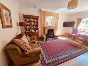 a living room with a couch and a fireplace at Pinetree Cottage, dog friendly, Holiday let, Callander Invertrossachs in Callander