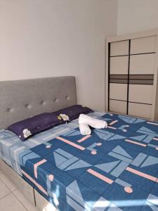1 dormitorio con 1 cama con edredón azul y blanco en Youth City Residence, Nilai Tower two rooms B 21, en Nilai