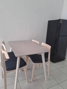 una mesa de madera y sillas con nevera en Youth City Residence, Nilai Tower two rooms B 21, en Nilai