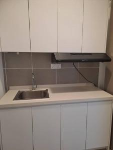 Una encimera de cocina con fregadero y microondas. en Youth City Residence, Nilai Tower two rooms B 21, en Nilai