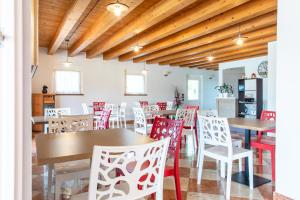 a dining room with tables and red chairs at B&B Ca' Marognole in Caprino Veronese