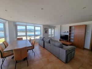 a living room with a couch and a table at Dúplex 4 dormitorios en Playa Rapadoira in Foz