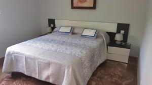 a bedroom with a bed with two pillows on it at SAUCES - PARKING GRATIS - CLIMATIZADO in Jaén +6 photos