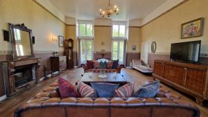 un grand salon avec un canapé et une télévision dans l'établissement House - Sleeps 10 - Garden - Pets Ok - Games Room, à Langoëlan