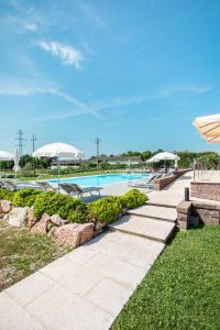 a swimming pool in a resort with umbrellas at B&B Ca' Marognole in Caprino Veronese