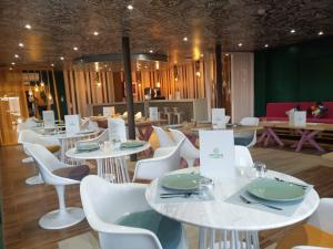 a dining room with white tables and white chairs at Oxygen Village in Zeïda