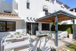 taras z białymi meblami i drewnianym parasolem w obiekcie Genteel Home Guadalvillas w Marbelli